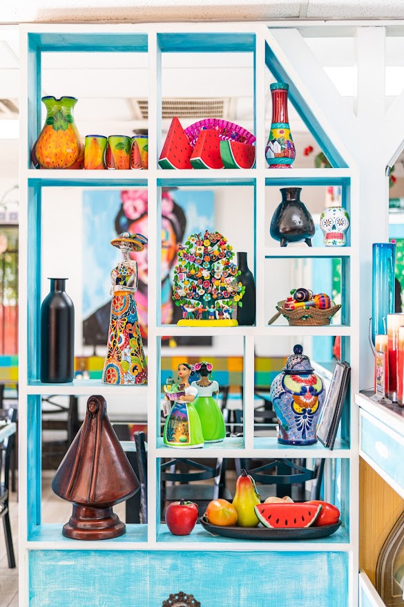 Estantería con artesanía mexicana: talavera, catrina, árbol de la vida y más